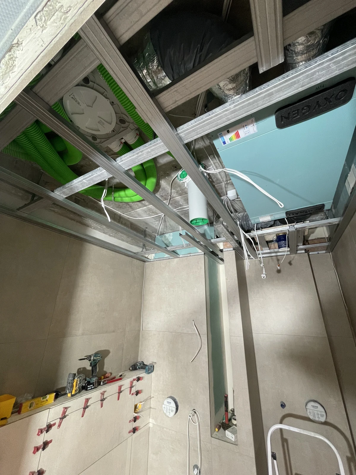 Ceiling framing and ventilation ductwork installed above the bathroom.