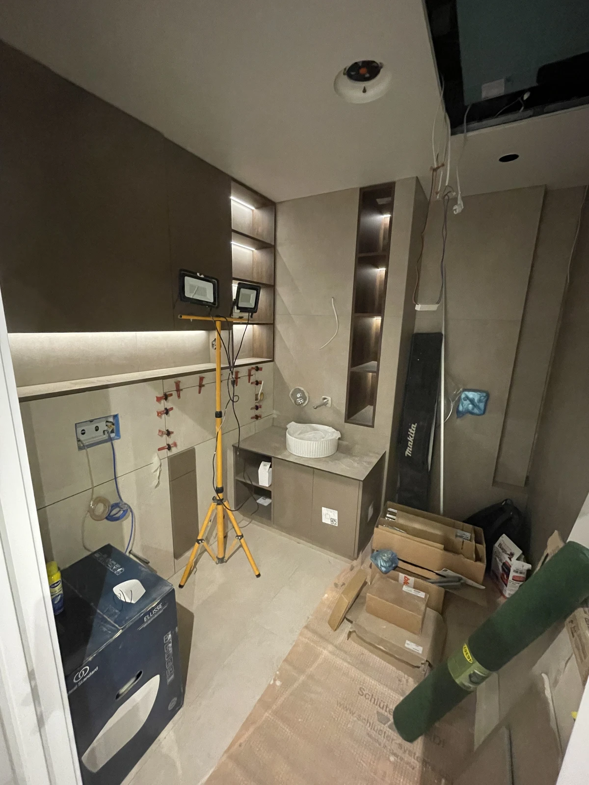 Basin, mirror and integrated lighting being installed during the final fit-out.