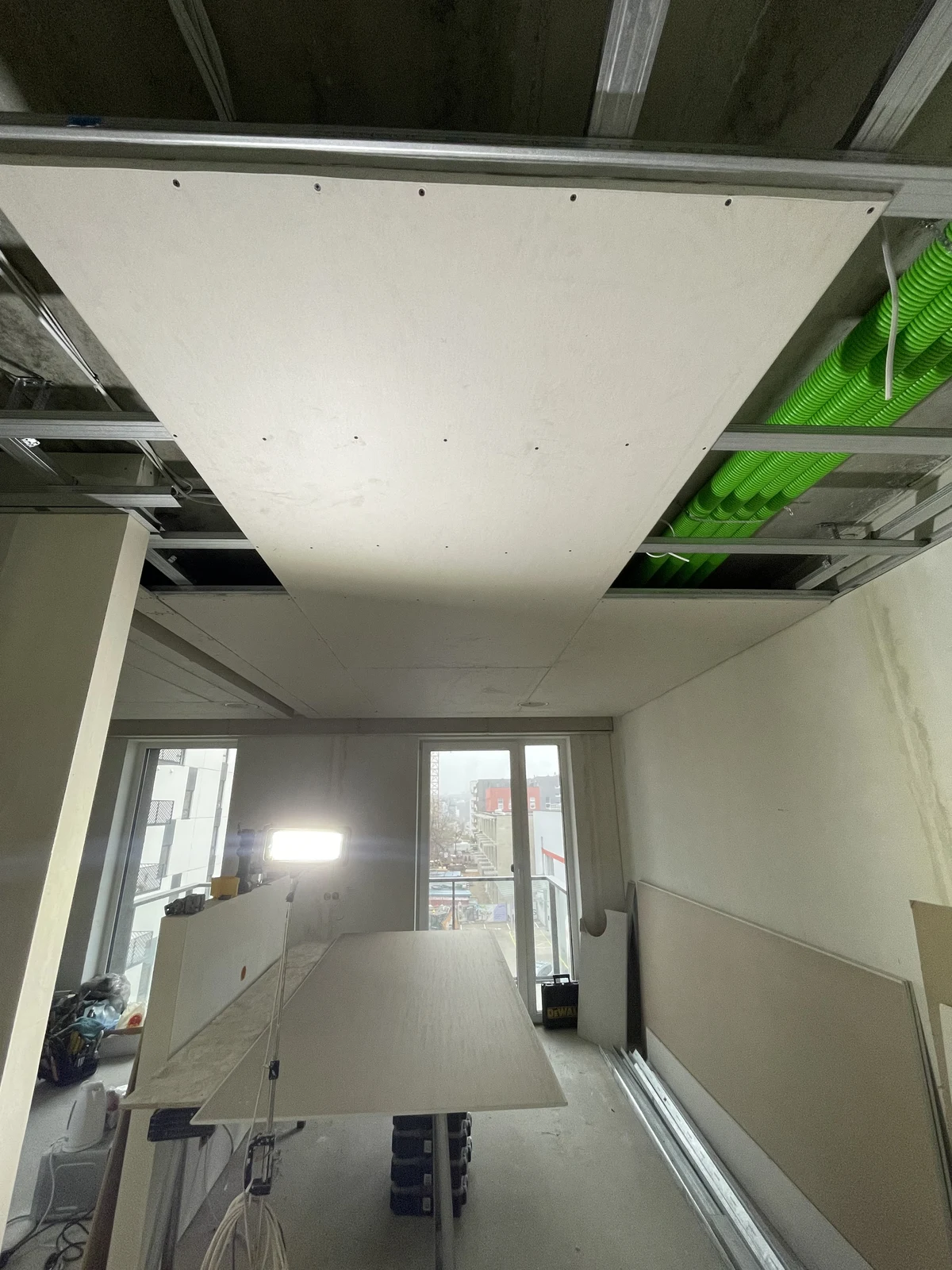 Ceiling framing, ventilation ducts and plasterboard installation in progress.