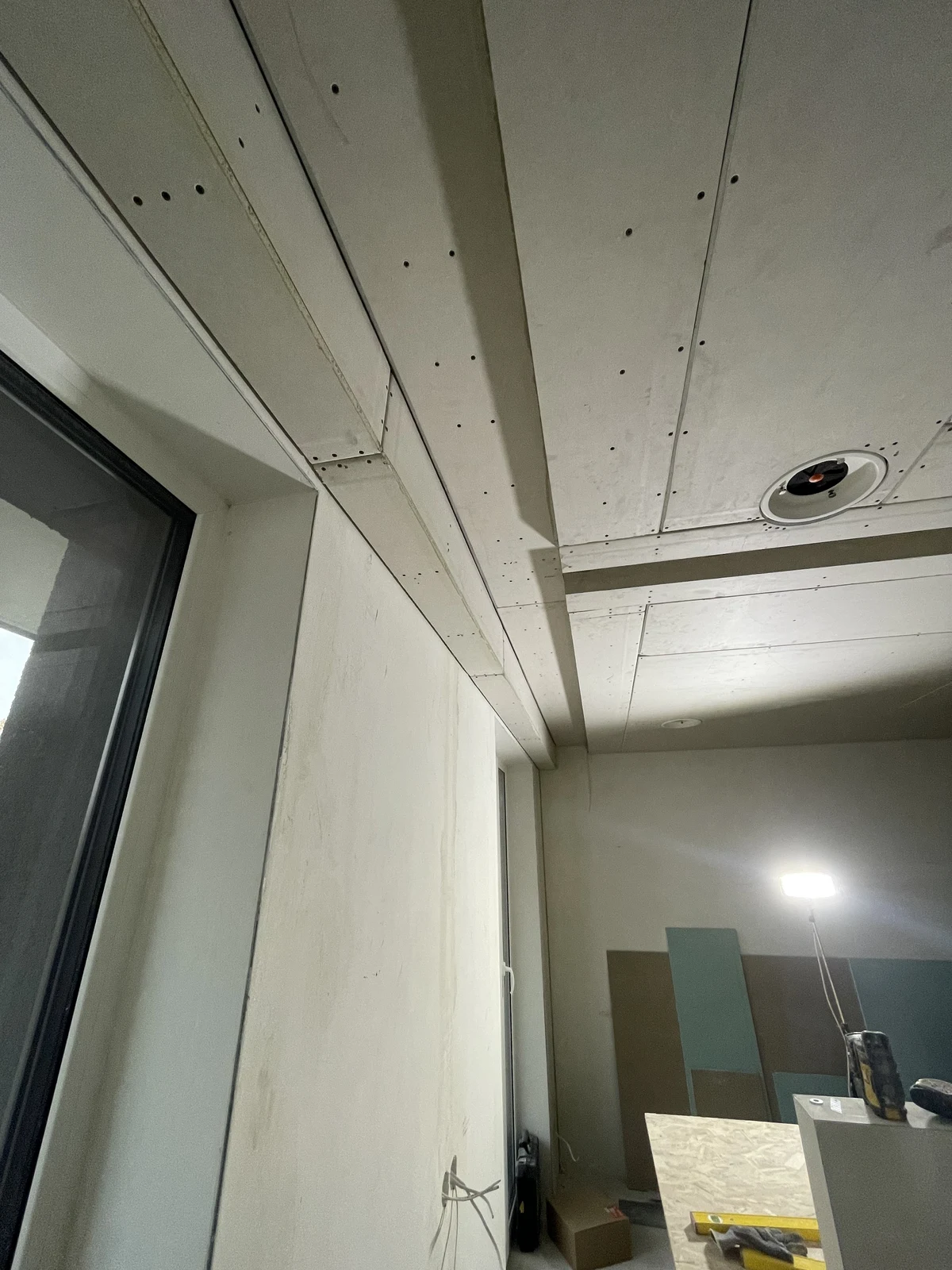 Ceiling boarding with openings prepared for the ventilation and lighting.