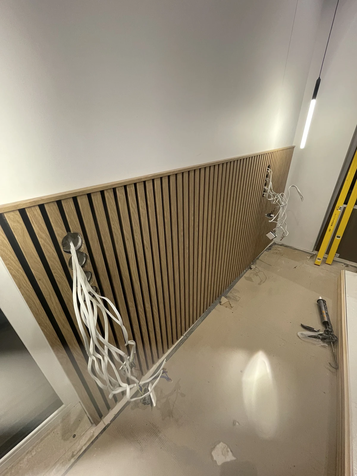 The slatted timber headboard wall and its wiring before completion.