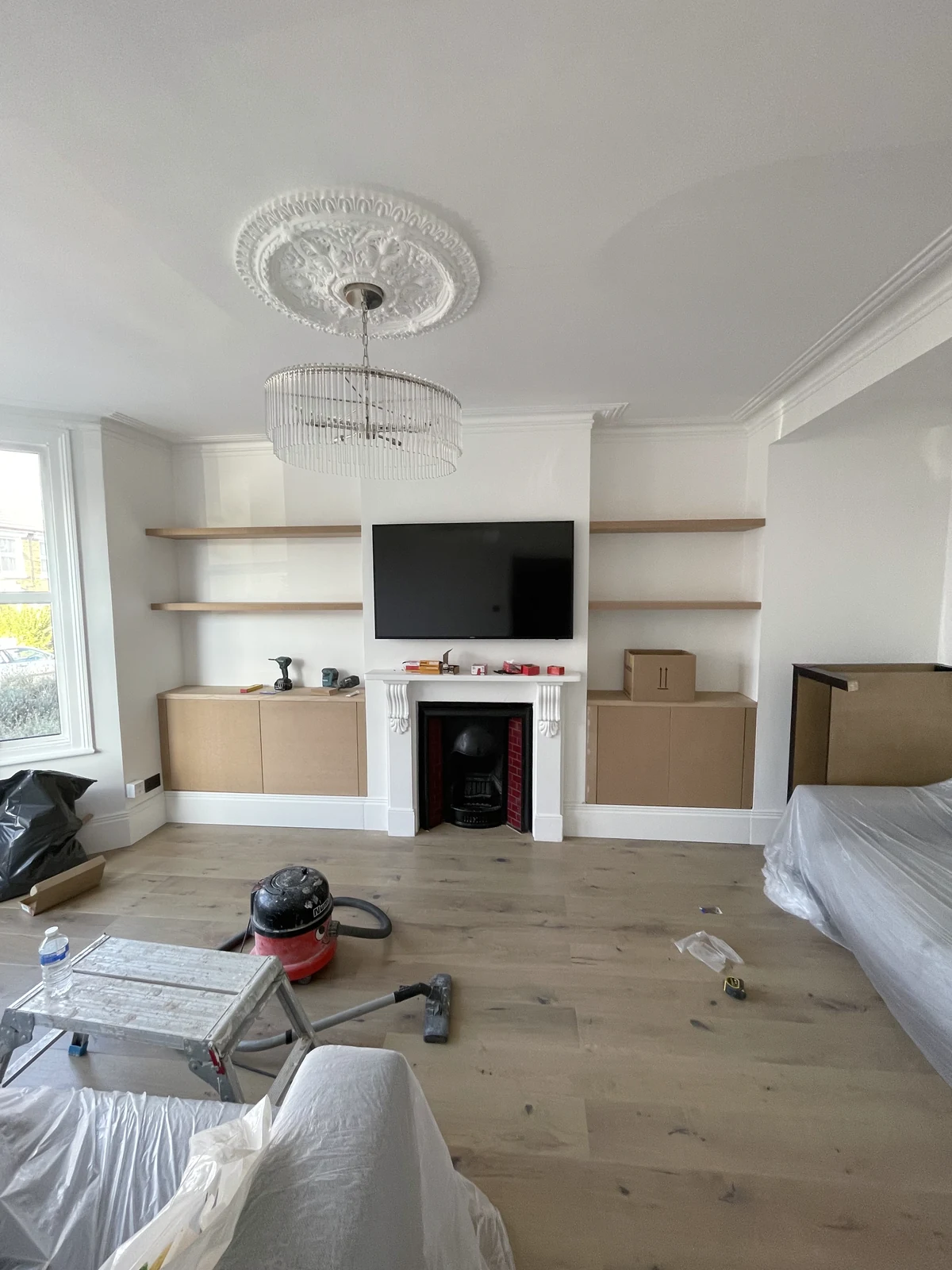 Living-room base cupboards and floating shelves during construction, before painting