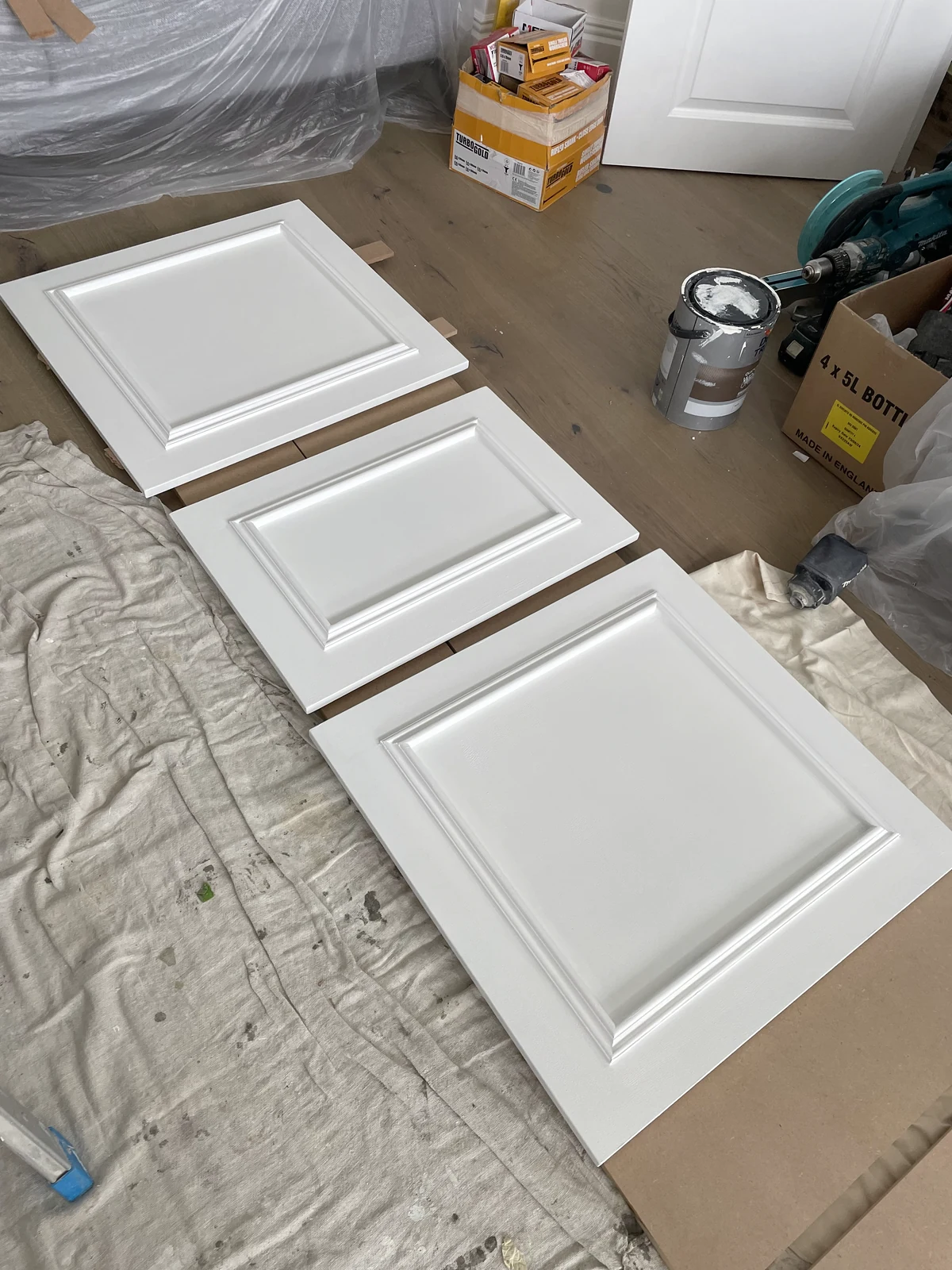 Panelled cupboard doors being prepared and painted before fitting
