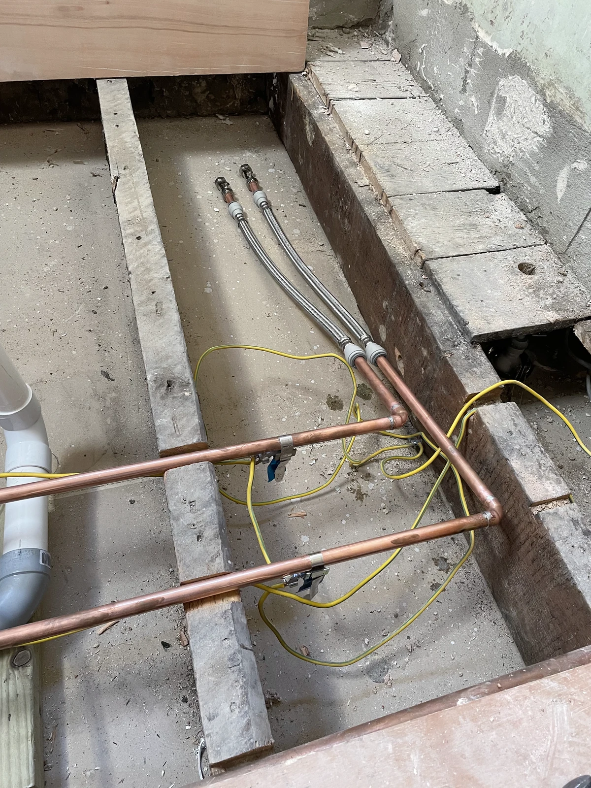 Pipework below the lifted floorboards during the refurbishment