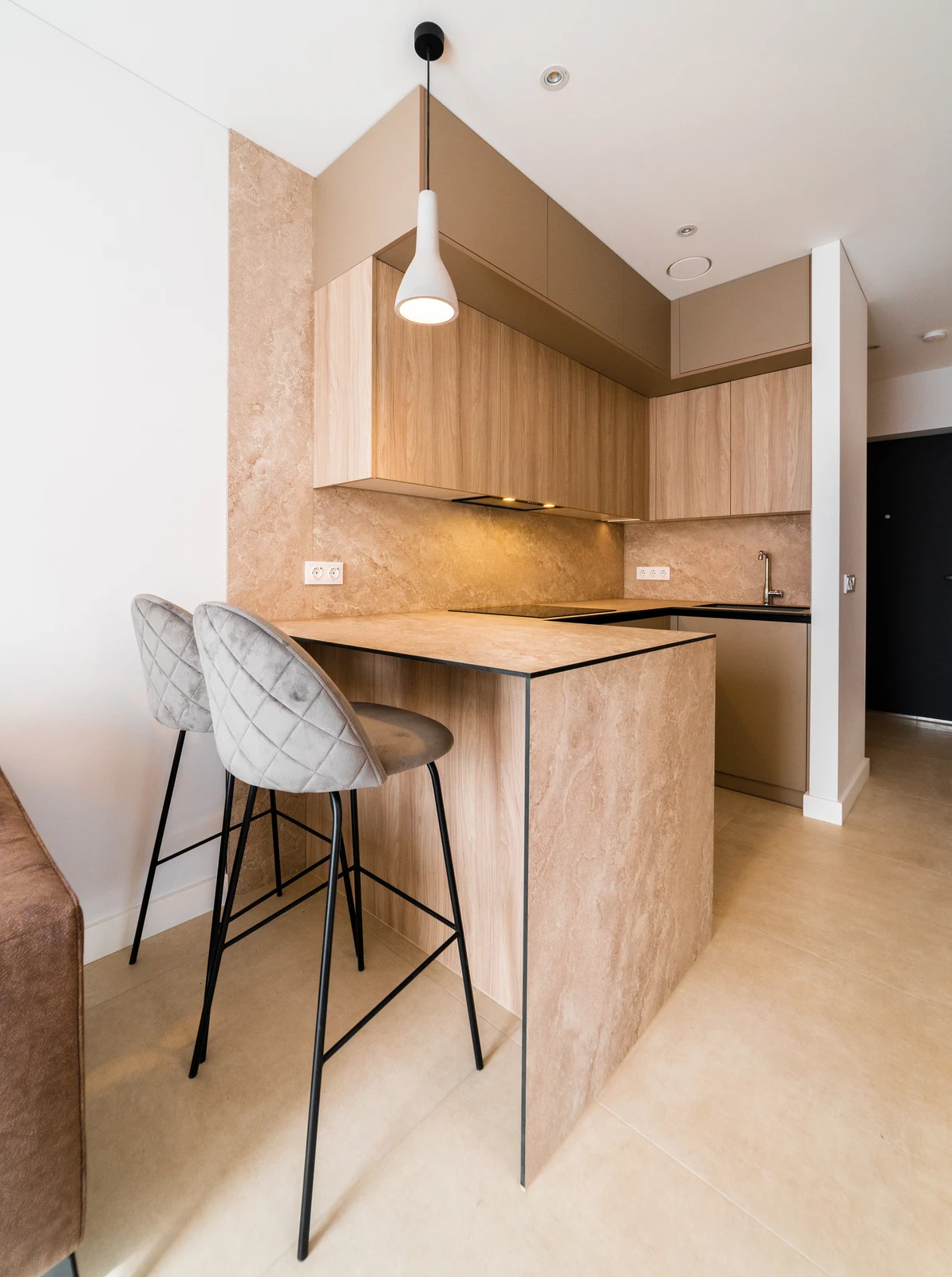 Finished kitchen with timber cabinetry, stone-effect worktop and breakfast bar