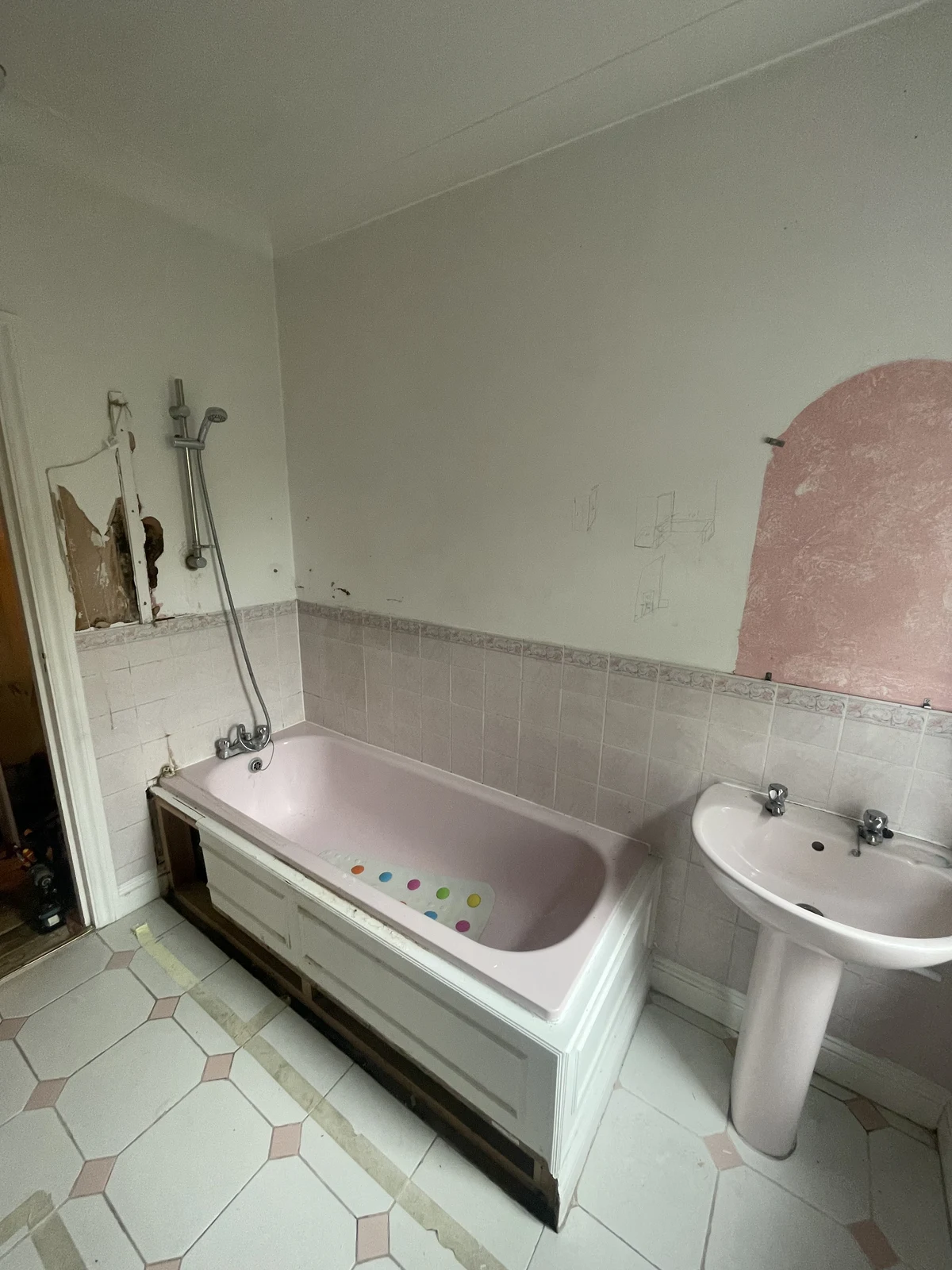 The pink bath, pedestal basin and shower fittings before refurbishment.