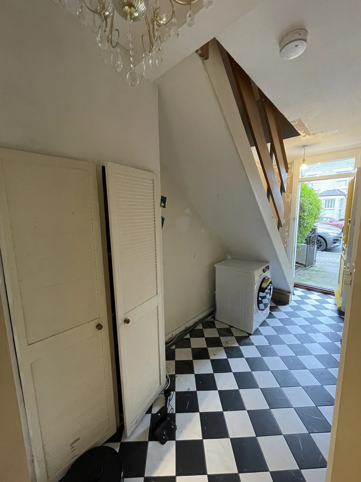 Original under-stair storage and washing machine before the bespoke hallway cabinets.