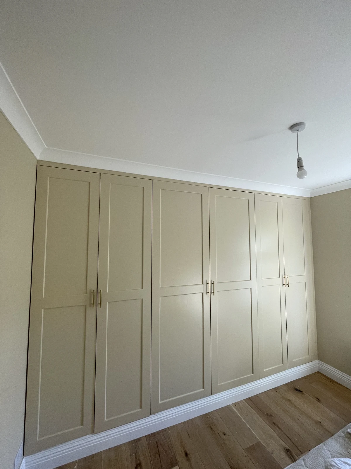 Panelled full-height bedroom wardrobes with fitted handles.