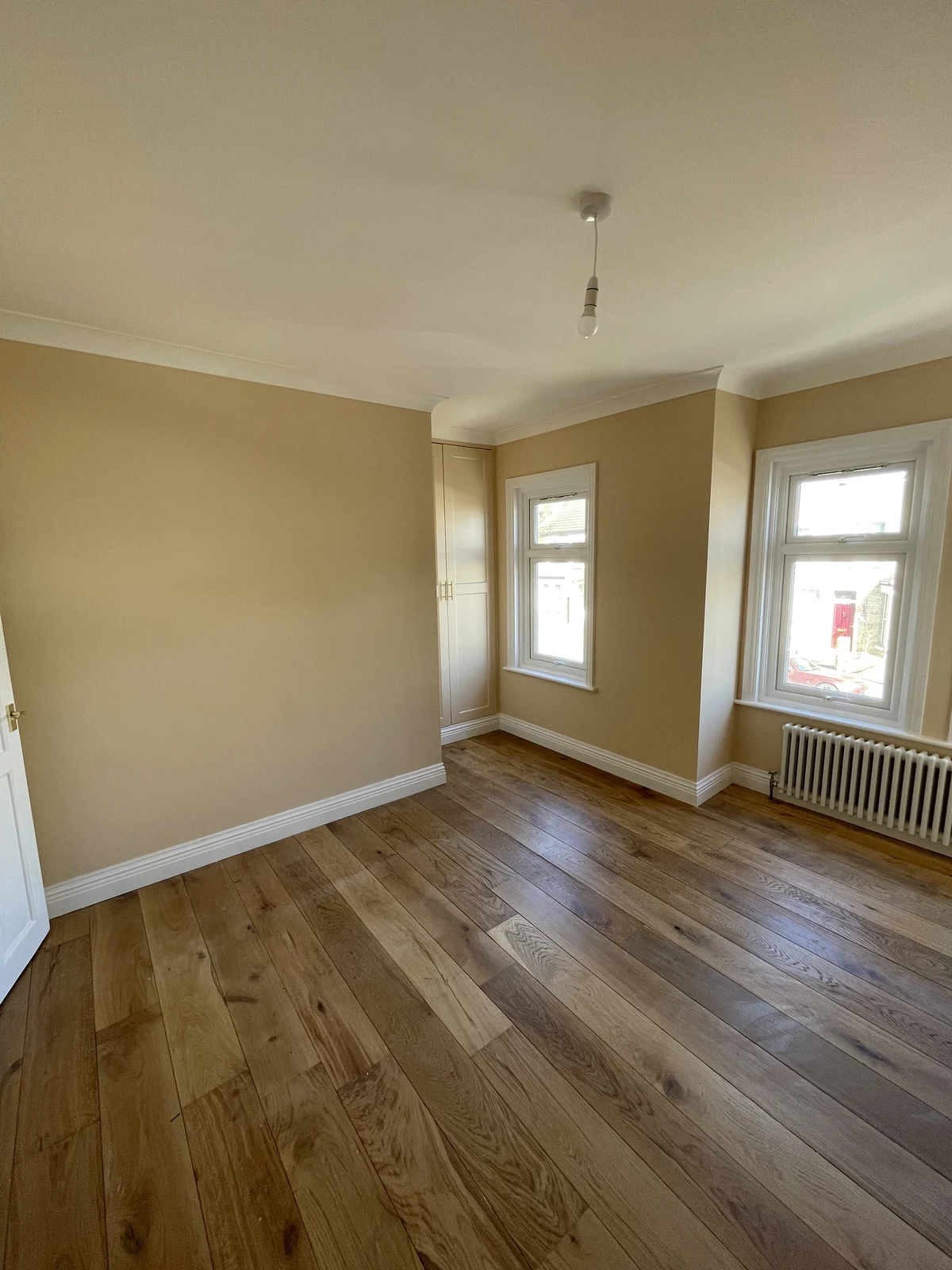 Bedroom view towards the windows and radiator.