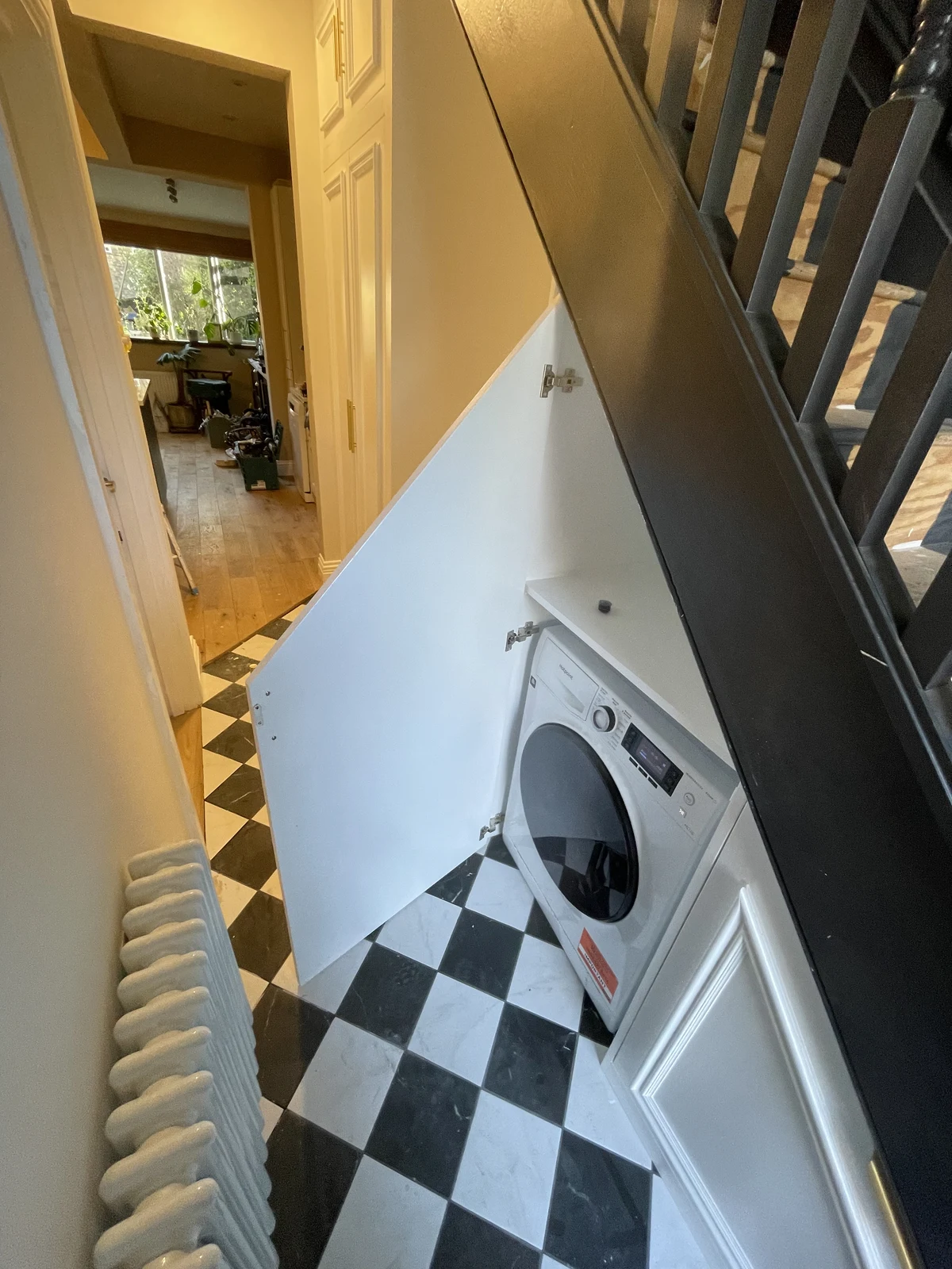Under-stair storage arranged around the washing machine.