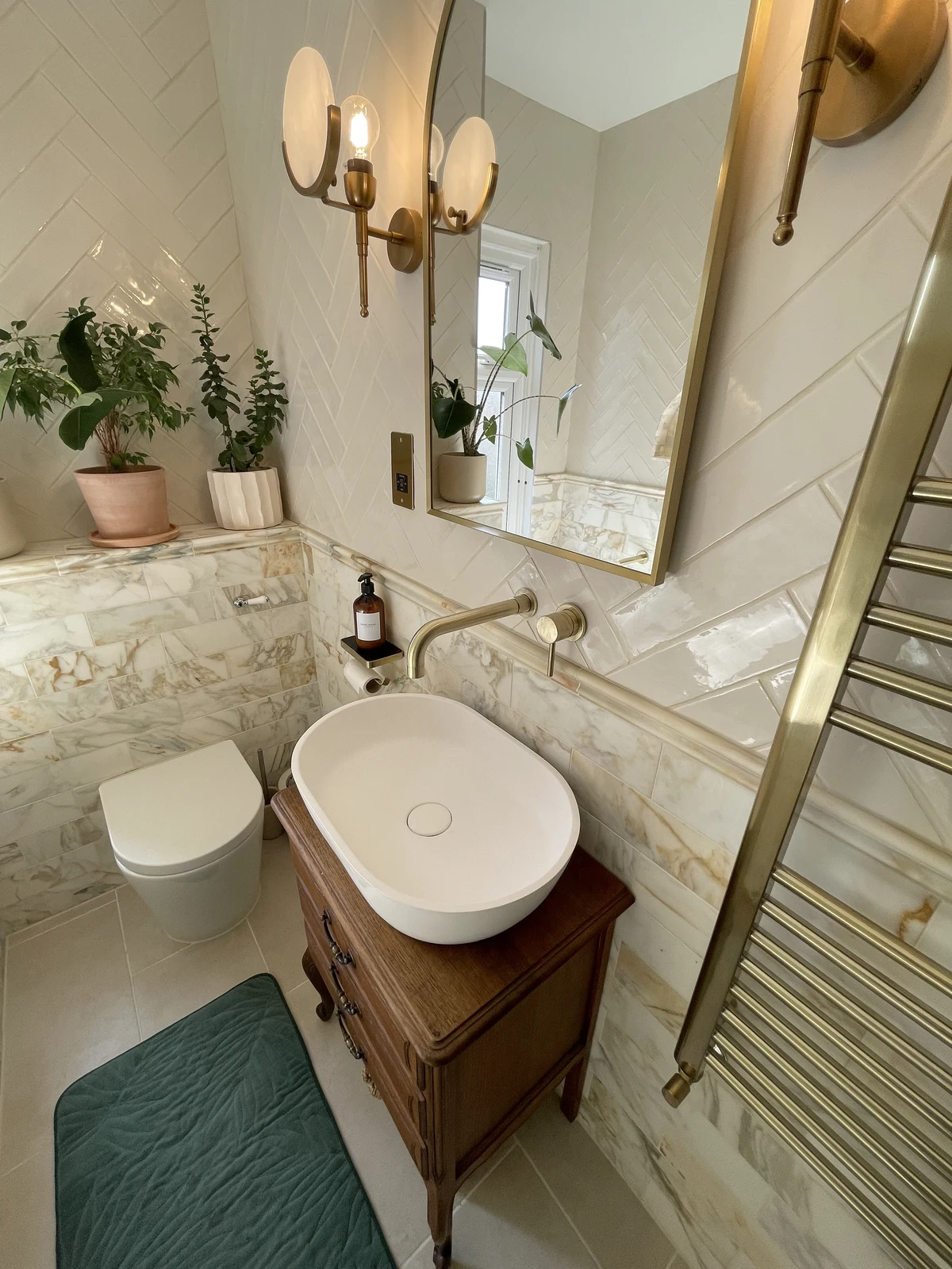 Timber vanity, countertop basin, wall-mounted mixer and illuminated mirror.