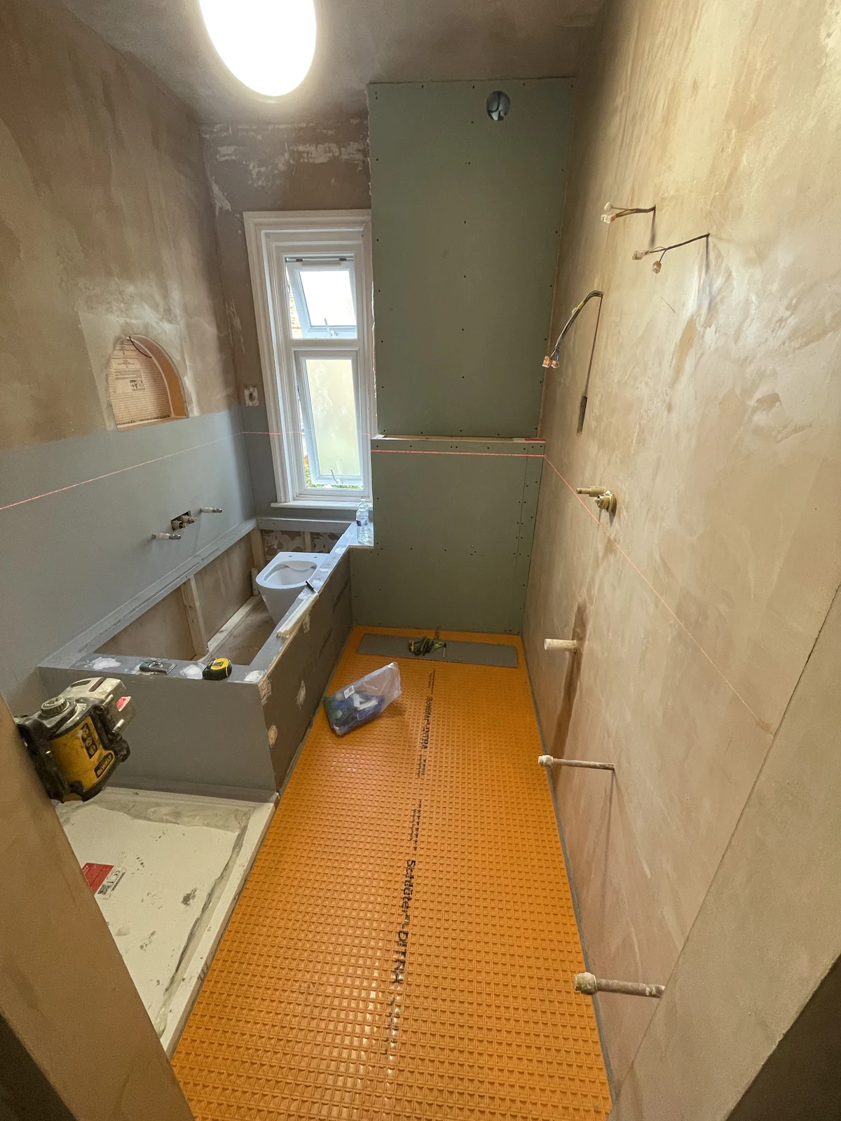 Uncoupling membrane laid across the bathroom floor before tiling.