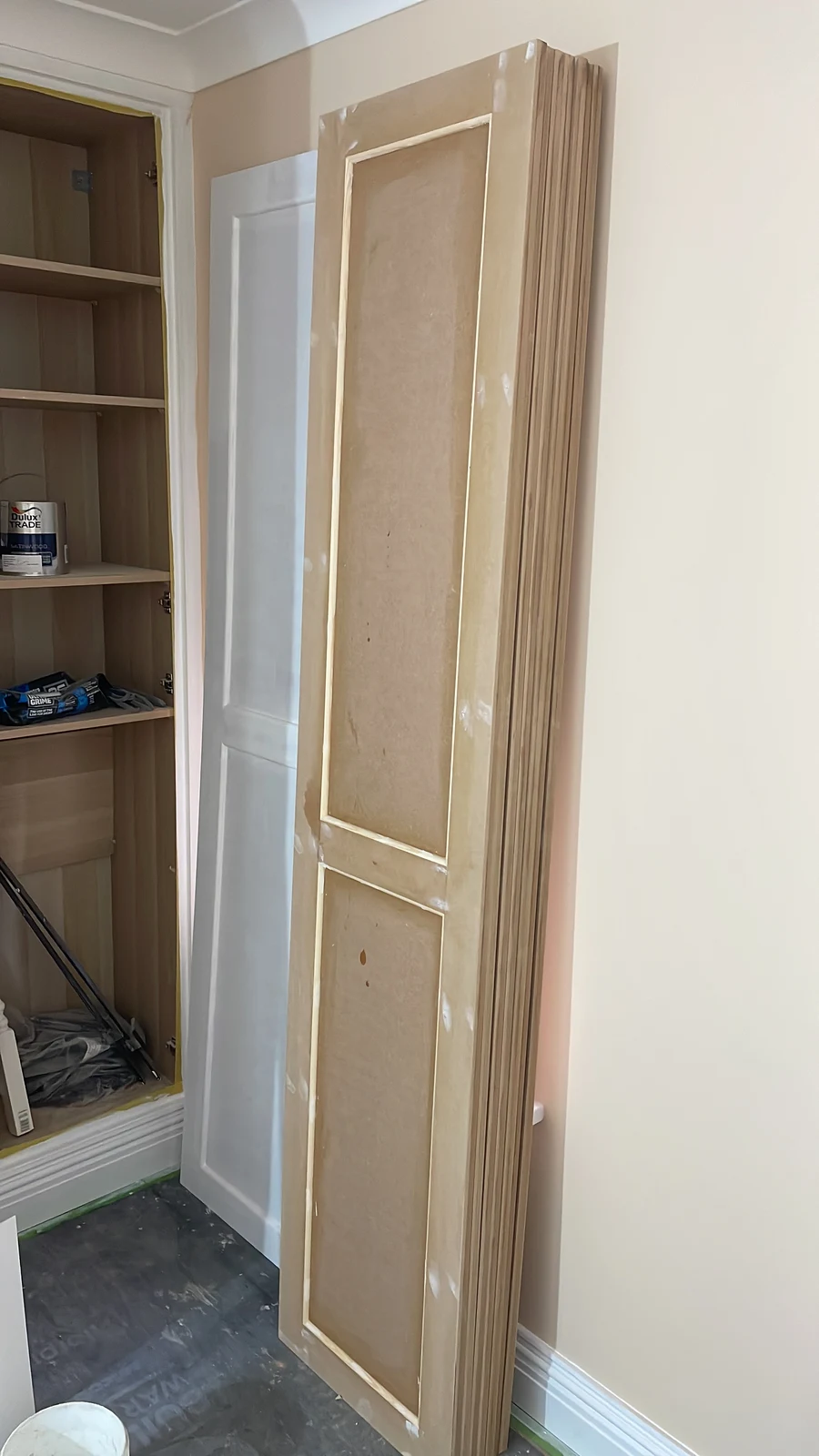 Panelled cupboard door being fitted to the bedroom storage.