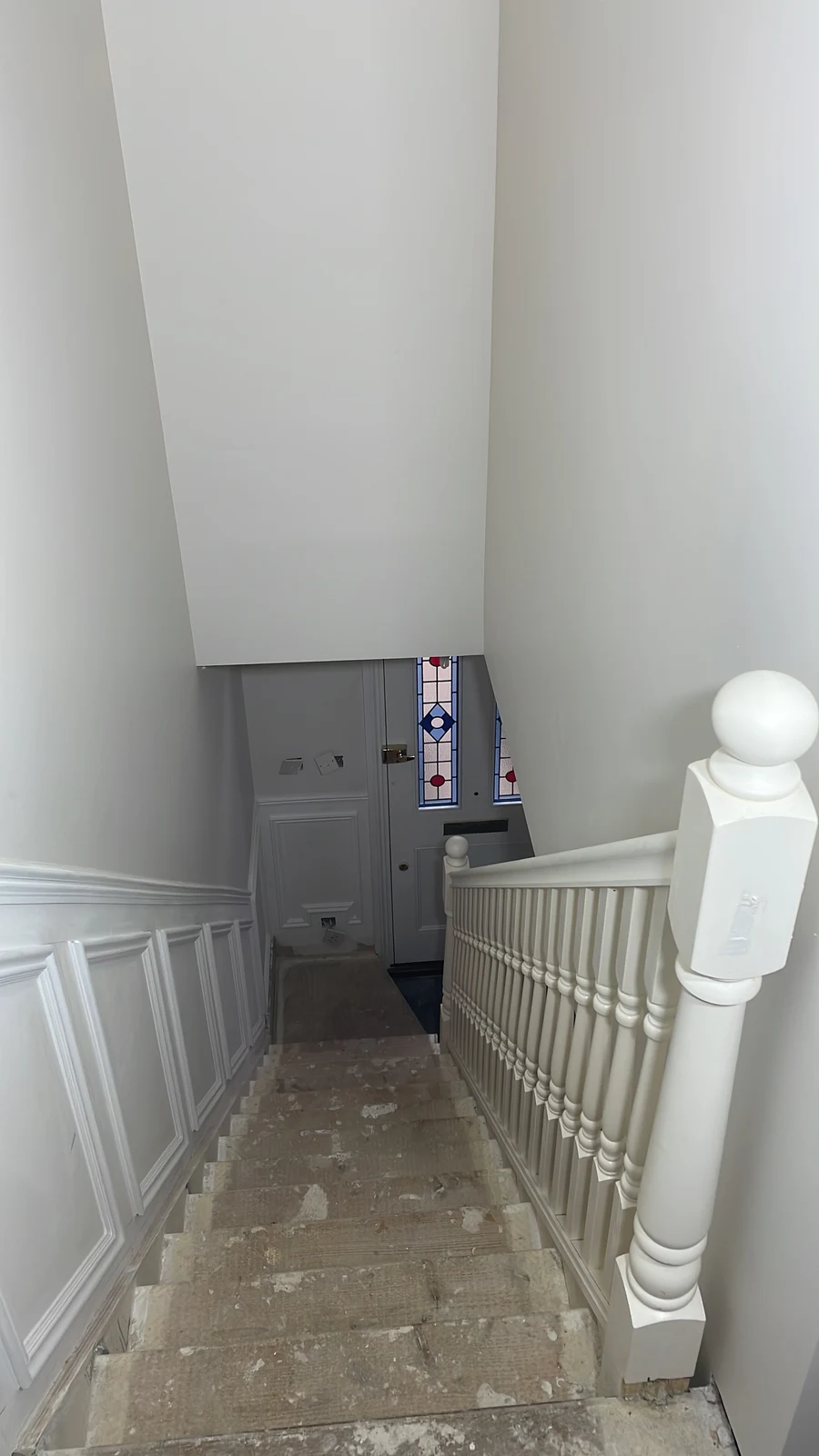 Staircase walls and balustrade painted while the treads remain unfinished.